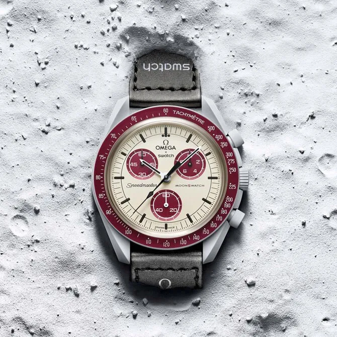 Swatch Omega - Mission to Pluto - a MoonSwatch piros és vajszínű, Pluto tematikájú verziója