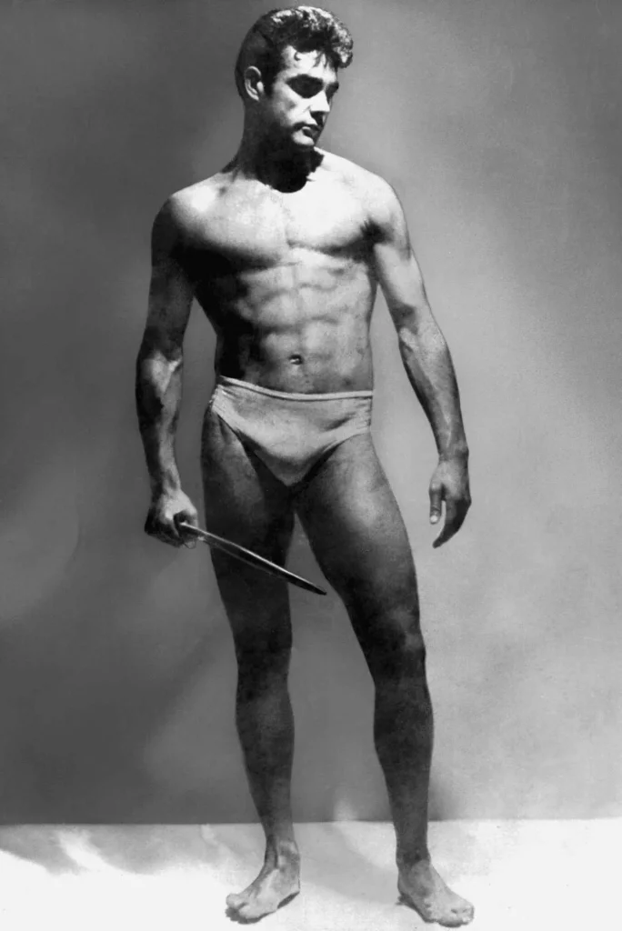 Sean Connery 1953-ban Mr. Universe-ként, karddal a kezében pózol. A titánok harca rovat méltó képviselője.