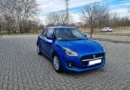 Suzuki Swift 1.2 Dualjet autó, kék színben, oldalsó elölnézetből, egy parkolóban állva