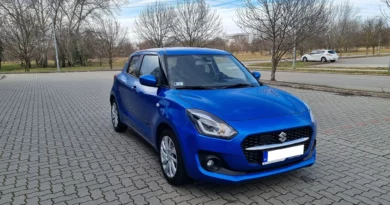 Suzuki Swift 1.2 Dualjet autó, kék színben, oldalsó elölnézetből, egy parkolóban állva